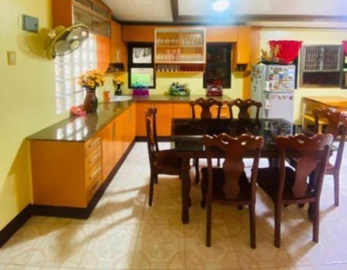 une cuisine avec une table, des chaises et un réfrigérateur dans l'établissement Namaste Olango Guesthouse by Hiverooms, à Sampong