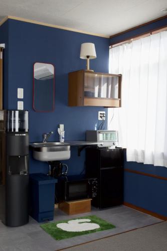 ein Badezimmer mit Waschbecken und einer blauen Wand in der Unterkunft Machicado in Tamano