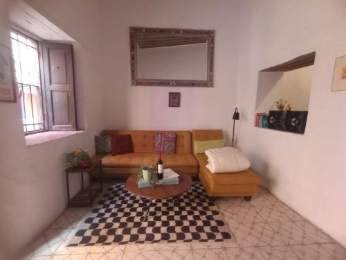 a living room with a couch and a table at Casa Posada Rústica - A 1 minuto del Jardín Unión in Guanajuato
