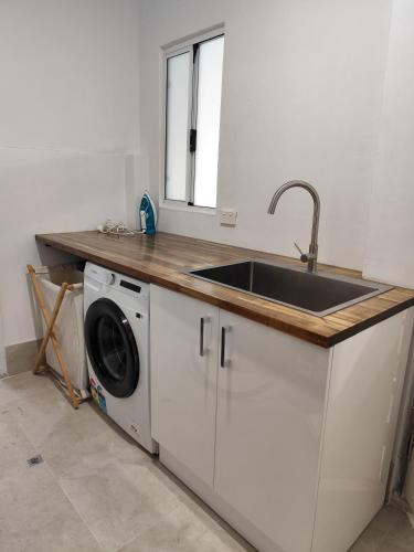 a kitchen with a sink and a washing machine at Kaivalya Niketan in Perth