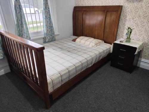 a small bed with a wooden frame in a bedroom at Kaivalya Niketan in Perth