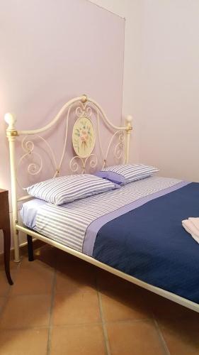 1 dormitorio con 1 cama con reloj en Borgo Franza Case Vacanze, en Basicò