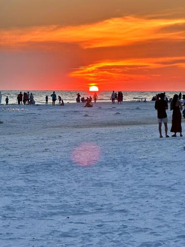 a group of people on a beach at sunset at Siesta Key Beach House in Siesta Key
