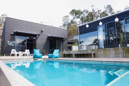 a swimming pool in front of a house at Quenda Guesthouse in Hovea