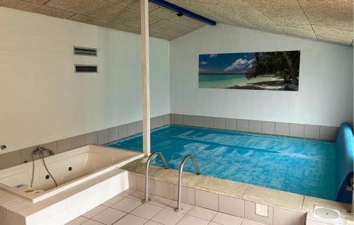 a large swimming pool in a bathroom with a bath tub at Awesome Home In Væggerløse With Sauna in Marielyst