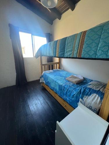a bedroom with a bunk bed and a window at Cabañas Refugio Lavanda in Villa de Las Rosas