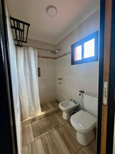a bathroom with a toilet and a sink at Refugio Serrano in Merlo