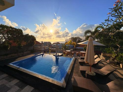 einen Pool mit Sonnenschirm, Stühlen und Sonnenschirm in der Unterkunft Pooja Ocean View Cottage in Nusa Penida
