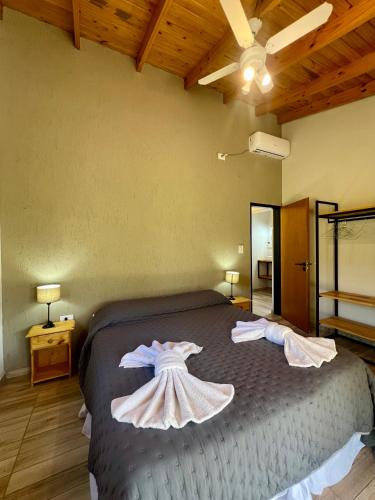 a bedroom with a bed with two dresses on it at Refugio Serrano in Merlo