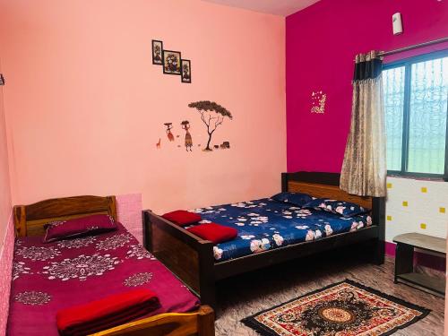 a bedroom with two beds and pink walls at TPS LODGE in Siruvallūr