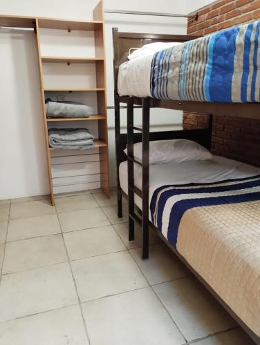 a bedroom with bunk beds and a tiled floor at Xaltepic tú casa in Amecameca de Juárez