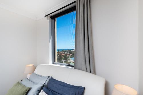 a room with a large window with a white couch at WELL82 - Ocean Heights in Mosman Park
