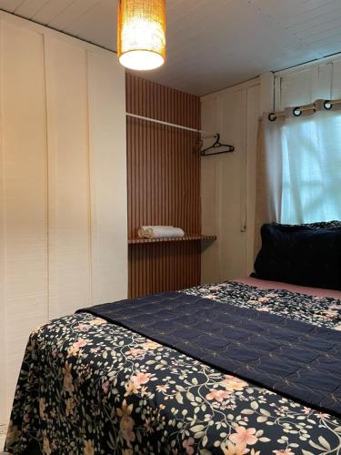 a bedroom with a bed with a flowered blanket at Santo Gole Ilha Do Mel in Ilha do Mel