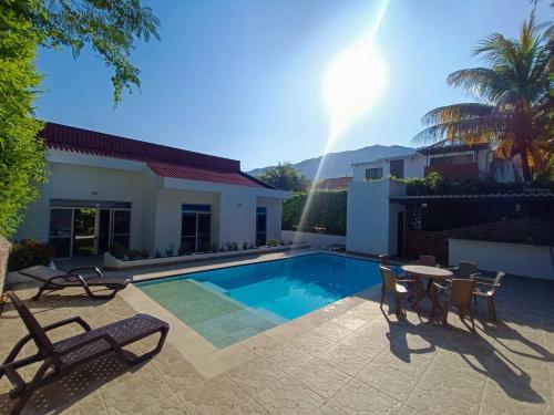 eine Villa mit Swimmingpool und Terrassenmöbeln in der Unterkunft Casa de Descanso con Piscina y Jardín Ricaurte in Ricaurte