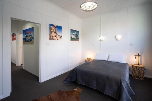 a bedroom with a bed in a white room at City Apartment - Steps to Cafés, Galleries & Coast in New Plymouth