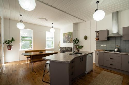 a kitchen with a sink and a table in it at City Apartment - Steps to Cafés, Galleries & Coast in New Plymouth