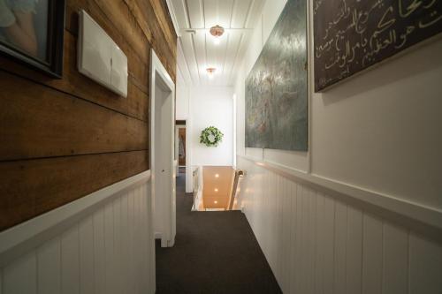 a hallway with white walls and a stairway at City Apartment - Steps to Cafés, Galleries & Coast in New Plymouth