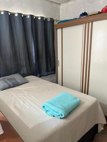 een bed met een blauwe handdoek erop bij Stúdio Viajante in Barcarena