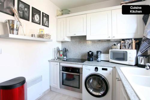 une cuisine avec un lave-linge et un micro-ondes dans l'établissement Coeur de Cannes - 2 pièces moderne, à Cannes