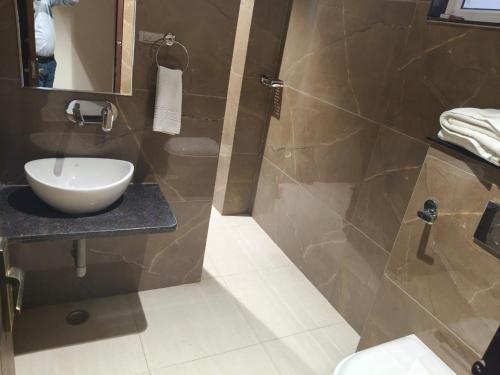 Un baño con lavabo y ducha en Samraddh Palace, en Alwar