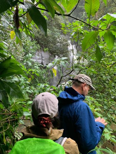 two people standing in front of a waterfall at Gam Maduwa , cooking class and Tours in Nuwara Eliya
