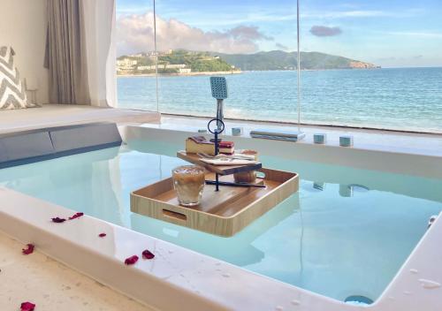 a glass table in a room with a view of the ocean at Shenzhen White House Nan'ao Beach Seaview guesthouse in Youcaopeng