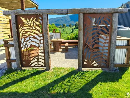 a garden gate with a bench in the background at Maungatapu Hut in Rai Falls