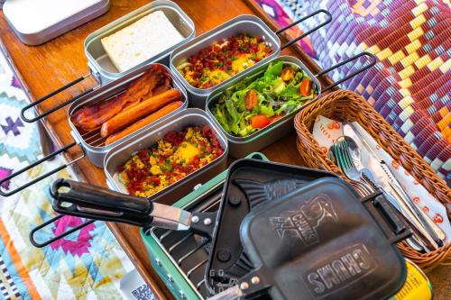 a table with four trays of food and aegerilusilusilusilusilus at Moyard Khaoyai in Ban Khanong Phra Klang (1)