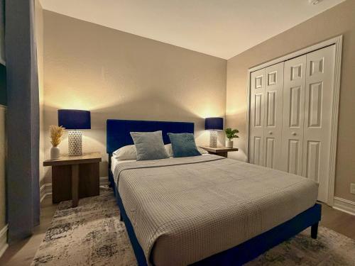 ein Schlafzimmer mit einem blauen Bett, zwei Tischen und einer Tür in der Unterkunft Close to Wilton Manors in Fort Lauderdale