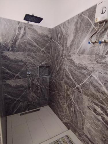 a bathroom with a black marble shower stall at Dom's Oase in Panglao Island
