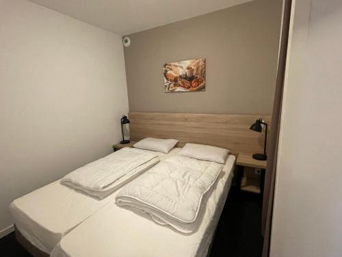 a small bedroom with a bed with white sheets at Studio à Gourette avec Piscine et Animaux Admis pour 6 Pers. - FR-1-860-41 in Gourette