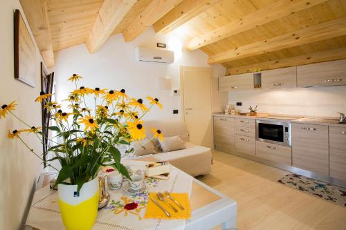 uma cozinha e sala de estar com um vaso de flores sobre uma mesa em Casa Sansovino em Pontecasale