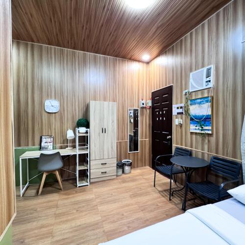 a room with a desk and a table and chairs at Malaybalay Air’bnb Travellers Inn in Malaybalay