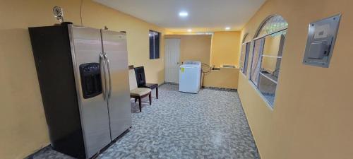 a room with a refrigerator and a table and chairs at Kinta Mae Foster in Marcelino