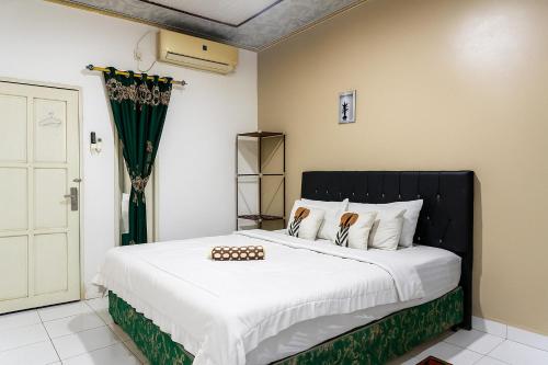 Ένα ή περισσότερα κρεβάτια σε δωμάτιο στο Namirah Syariah Guesthouse Balikpapan Redpartner