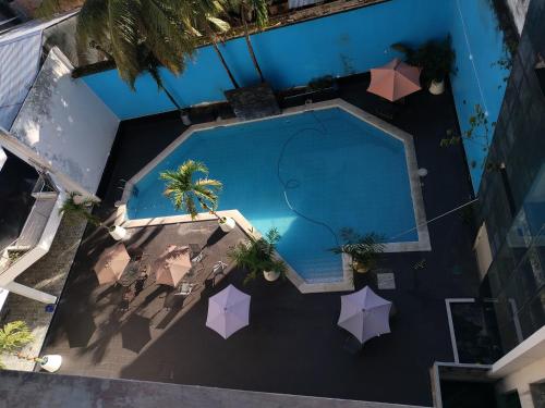 Una vista aérea de una piscina con sombrillas. en Alojamiento CASA LUNA, en Iquitos