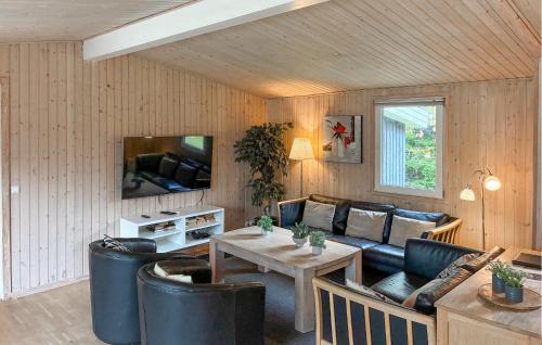 a living room with a couch and a table at Awesome Home In Væggerløse With Sauna in Marielyst