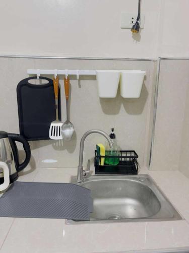 a kitchen sink with a dish rack and utensils at Potot Haven Dorm and Transient in Libmanan