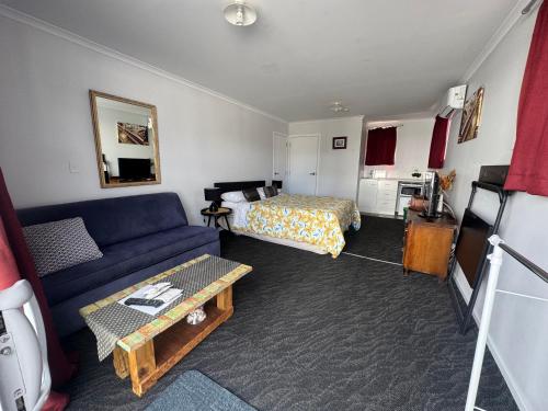 a living room with a couch and a bed at DELBROOK POINT COZY-STUDIO in Hamilton