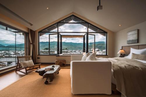 a bedroom with a large bed and a large window at GengYun Hot Spring Resort Hotel in Niujie