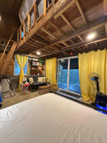 a bedroom with a bed and a living room at Elnora's Farm in Lucban
