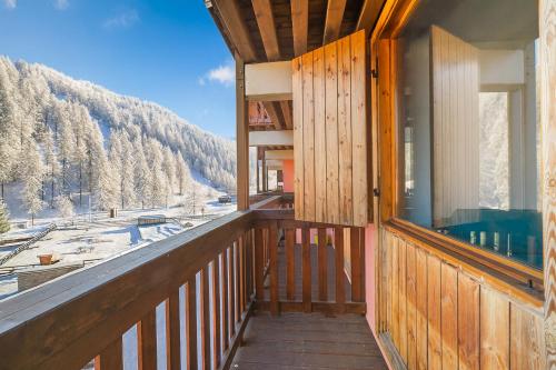 Elle comprend un balcon en bois offrant une vue sur la montagne. dans l'établissement Studio Valleverde 21D Ski In Ski Out - Happy Rentals, à Borgata Sestriere