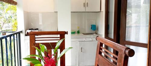 a kitchen with white cabinets and a wooden chair at MN House in Unawatuna