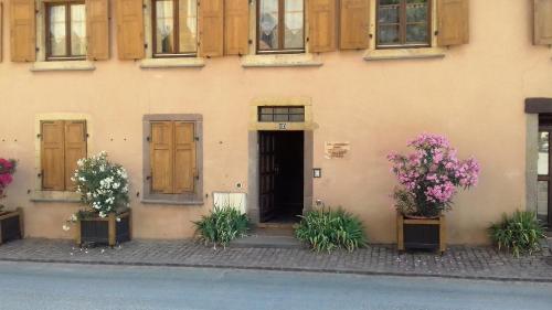 a building with flowers in front of a door at Gite Notre Dame in Rouffach