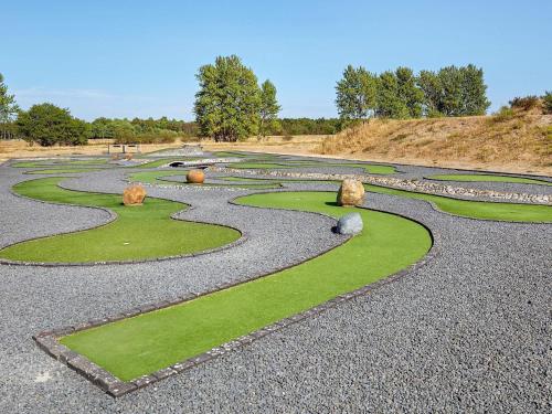 a garden with grass and rocks on a hill at Holiday home on a holiday park in Ebeltoft in Ebeltoft