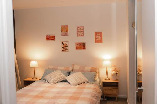 une chambre avec un lit et deux lampes sur deux tables dans l'établissement Cosy modern 2BR home in the heart of Melbourne CBD, à Melbourne