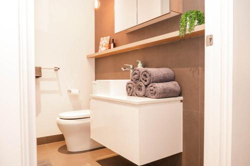 une salle de bain avec toilettes et serviettes sur un comptoir dans l'établissement Cosy modern 2BR home in the heart of Melbourne CBD, à Melbourne