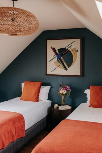 two beds in a room with green walls at Domaine des Pousses, Chambres d'hôtes au coeur d'un village de campagne in Droue-sur-Drouette