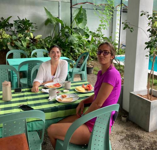dos mujeres sentadas en una mesa comiendo comida en Sudu Colonial House 1929, en Ambalangoda
