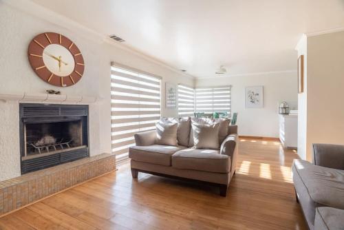 a living room with a couch and a clock over a fireplace at Beautiful Home at Ensenada 3BR at DT BBQ GRILL in Ensenada